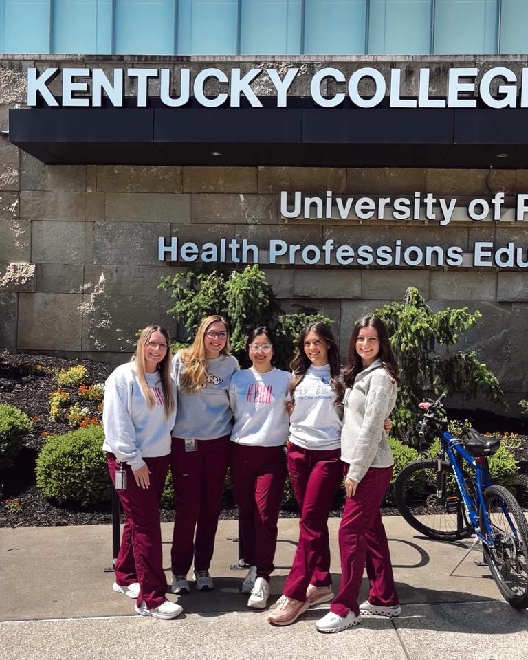 Five students stand in front of the Kentucky College of Optometry School